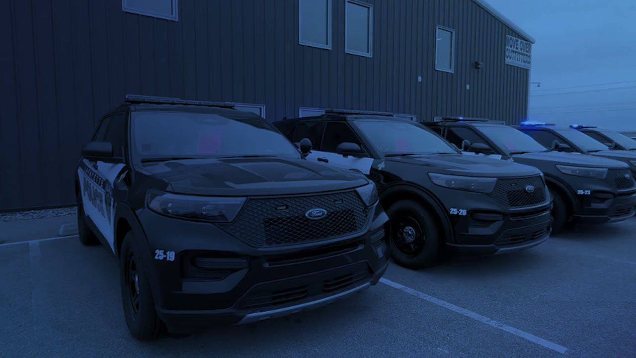Row of police SUVs parked outside the Move Over Outfitters shop