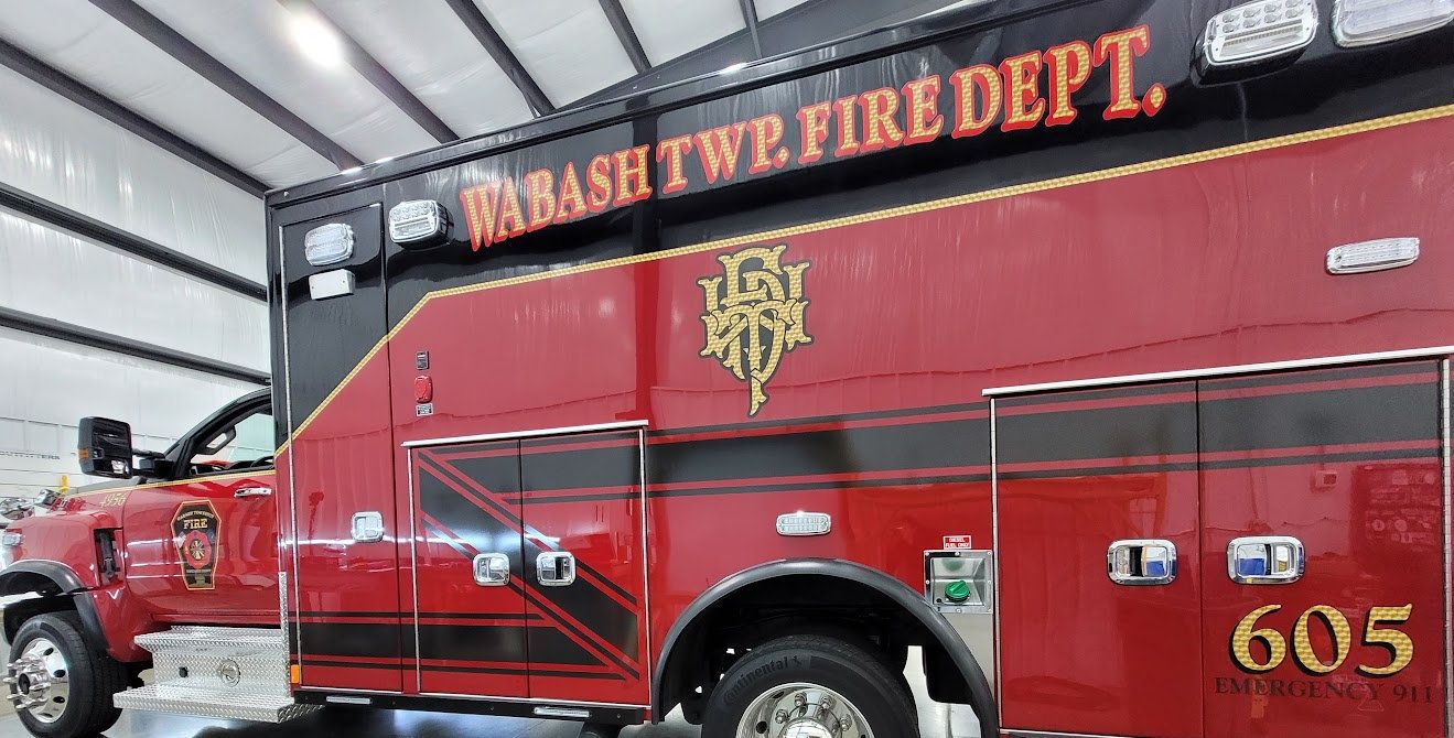 Red fire department apparatus with gold lettering and reflective striping